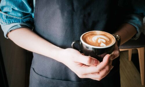 illustration d'un barista tenant une tasse rempli de café