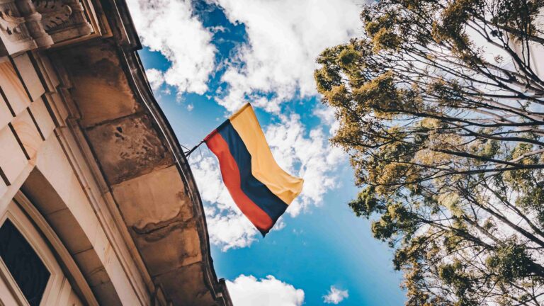 photo d'un drapeau colombien en haut d'un bâtiment avec le ciel en arrière plan